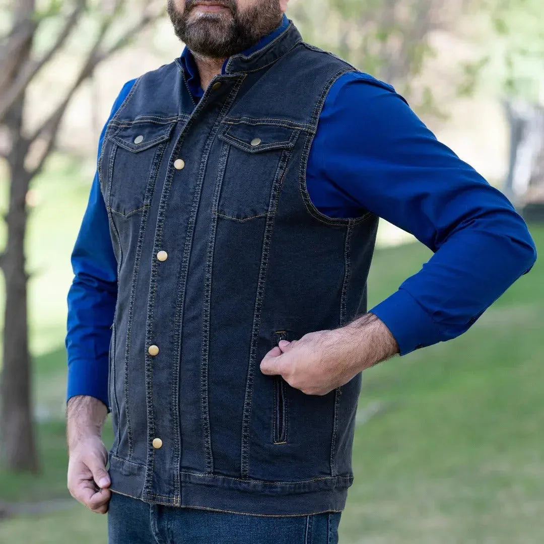 Man wearing dark denim vest over blue shirt outdoors, casual men's fashion