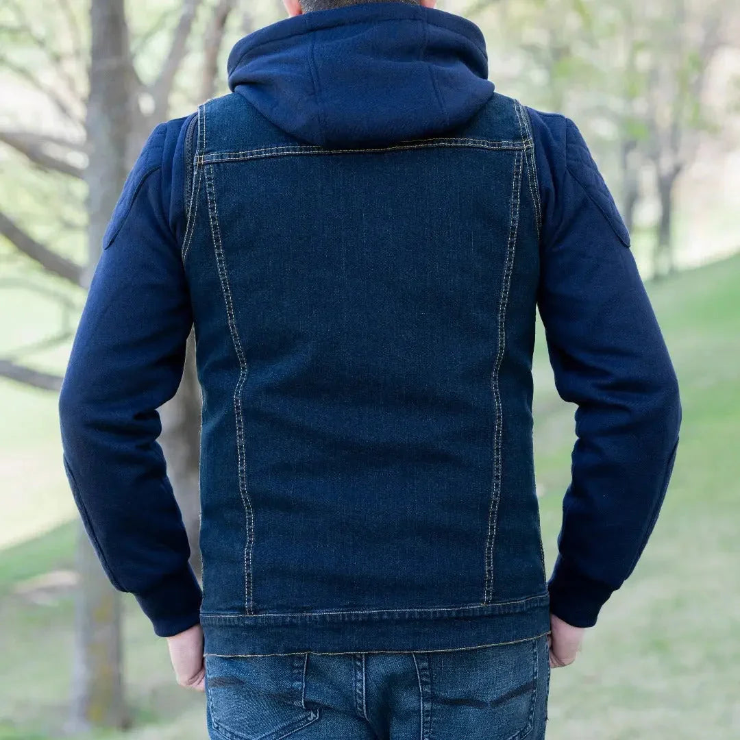 Man wearing a denim vest with blue hoodie and sleeves outdoors