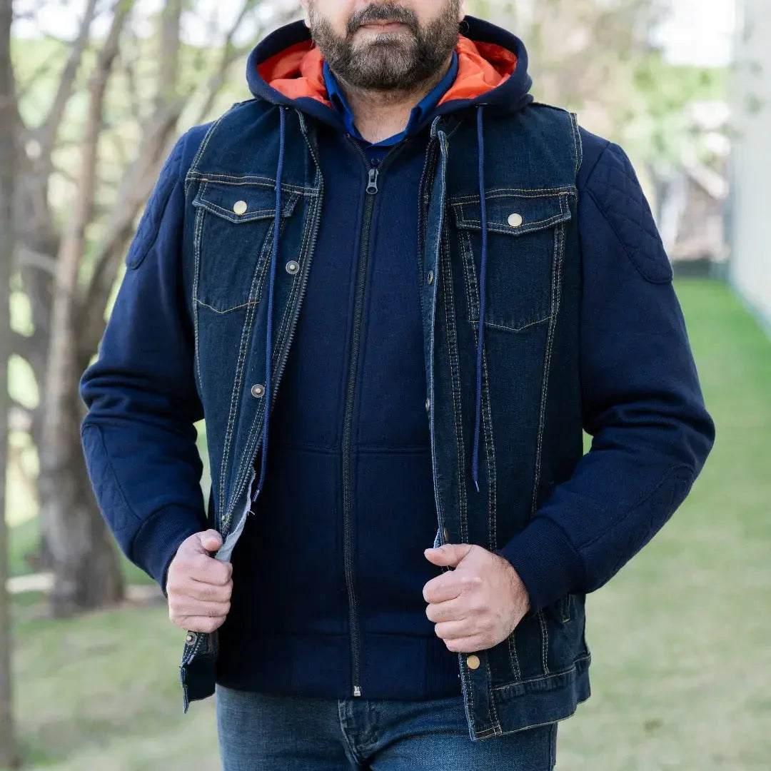 Man wearing a versatile denim vest with hoodie over a navy sweatshirt outdoors