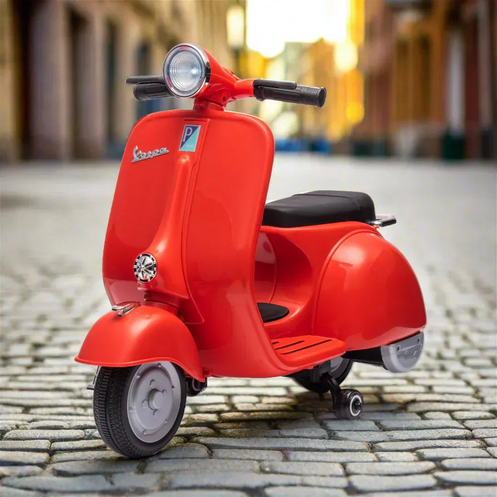 Red vintage Vespa scooter parked on cobblestone street in city setting