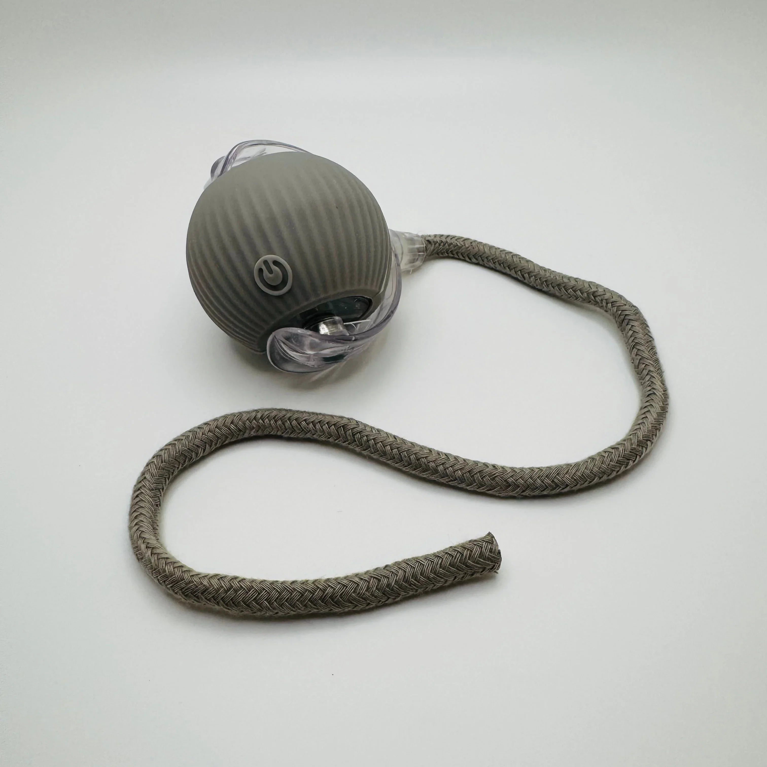Gray textured pet toy ball with long braided rope on white background