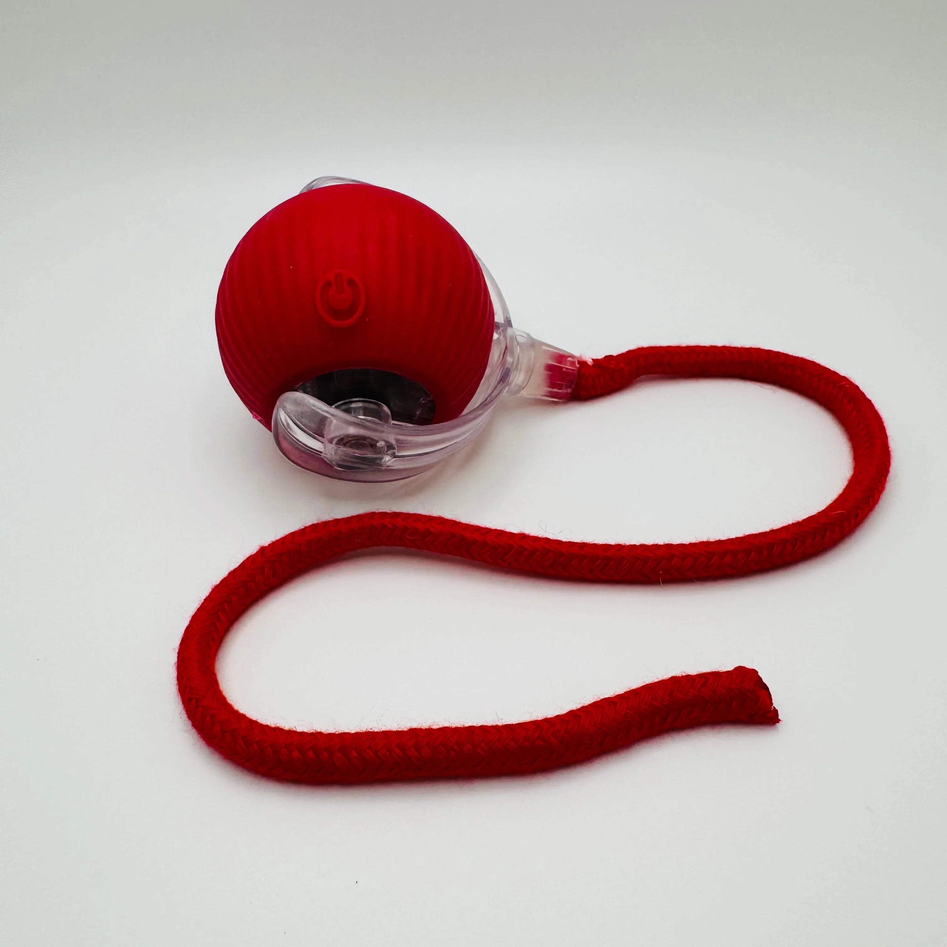 Red interactive pet toy ball with power button and attached red leash on white background