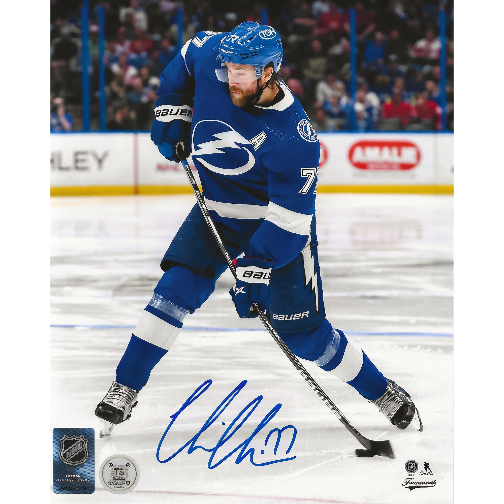 NHL Tampa Bay Lightning hockey player in blue uniform skating on ice, signed photo.