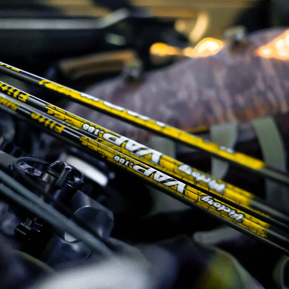 Victory VAP Elite 166 yellow carbon arrows close-up with camouflage archery gear