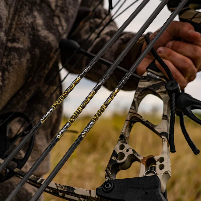 Hunter holding camo compound bow with Victory RIP 400 arrows outdoors