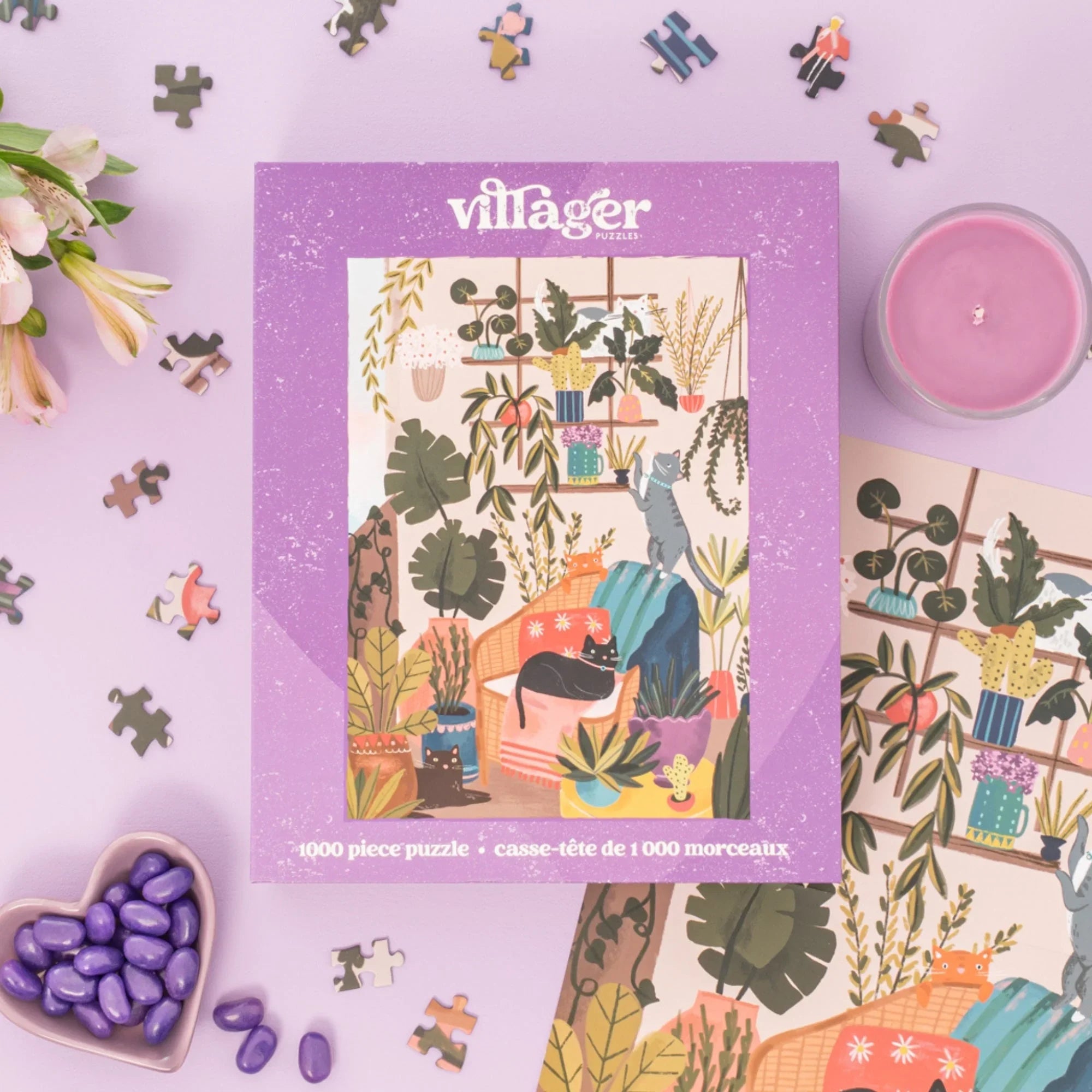 1000 piece cat and plant puzzle on purple table with candle, flowers, and heart candy dish