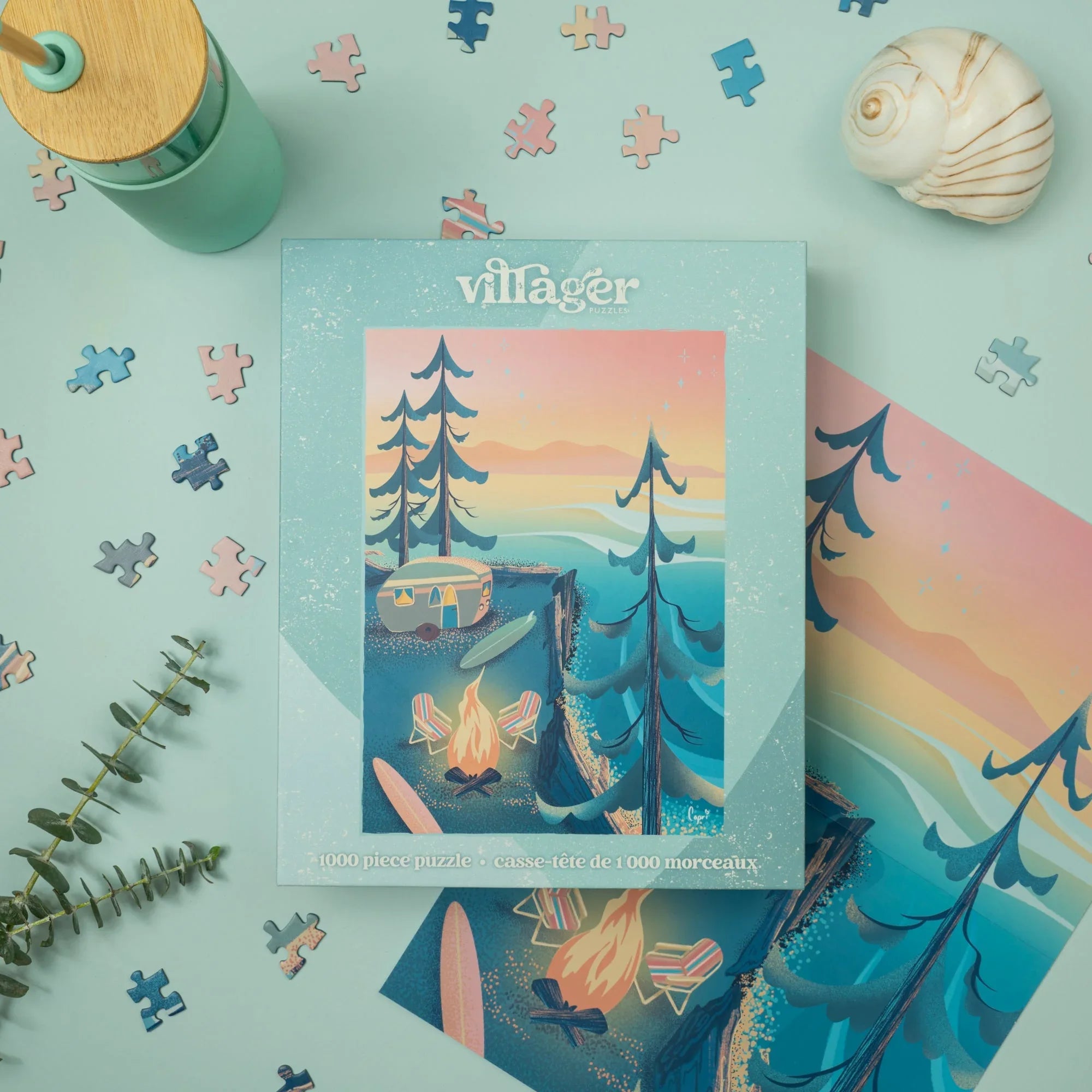 Coastal camping puzzle box with campfire, surfboards, and ocean sunset on blue background