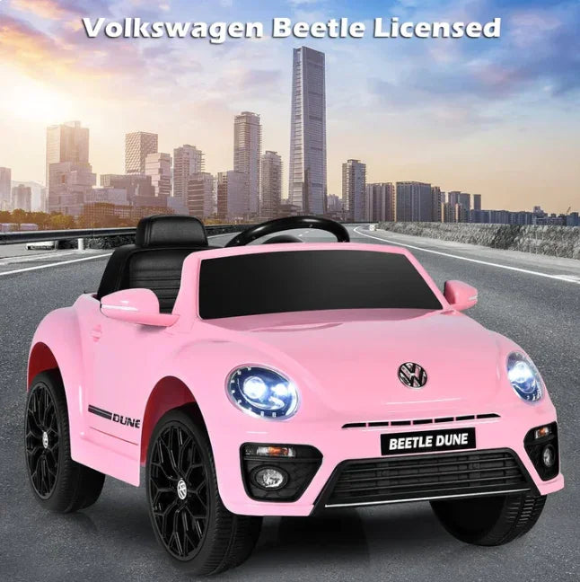 Pink Volkswagen Beetle Dune kids ride-on car on a city road with skyscrapers background