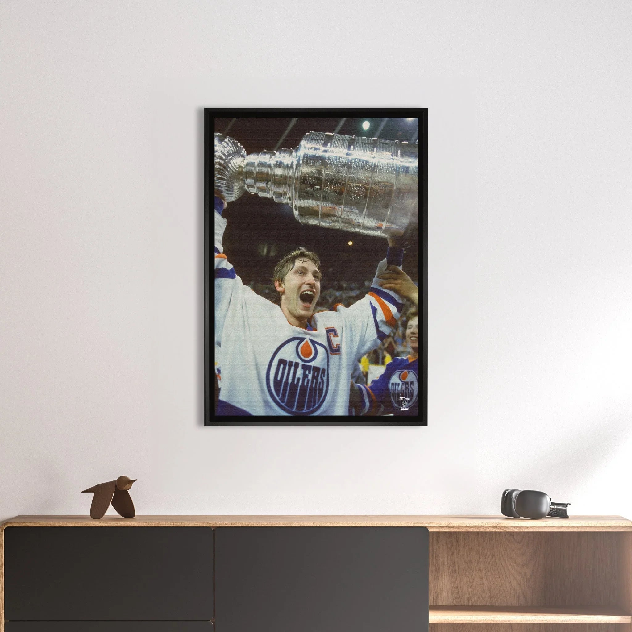 Framed hockey art print of Oilers player celebrating with Stanley Cup on modern wall