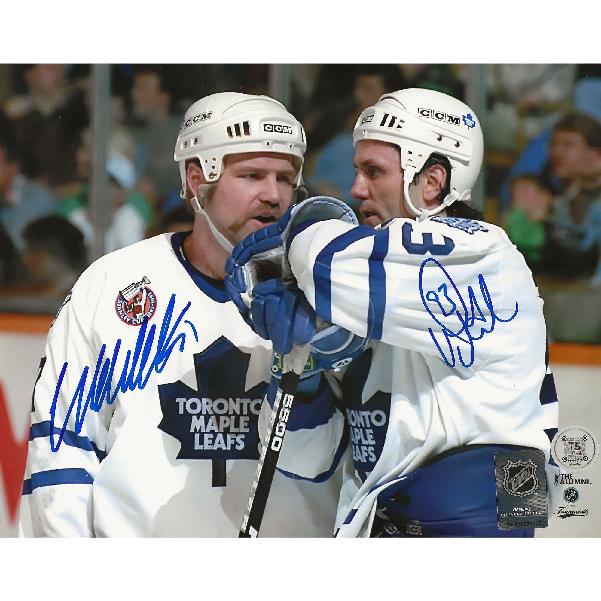 Two Toronto Maple Leafs hockey players in white jerseys during a game, both autographed.