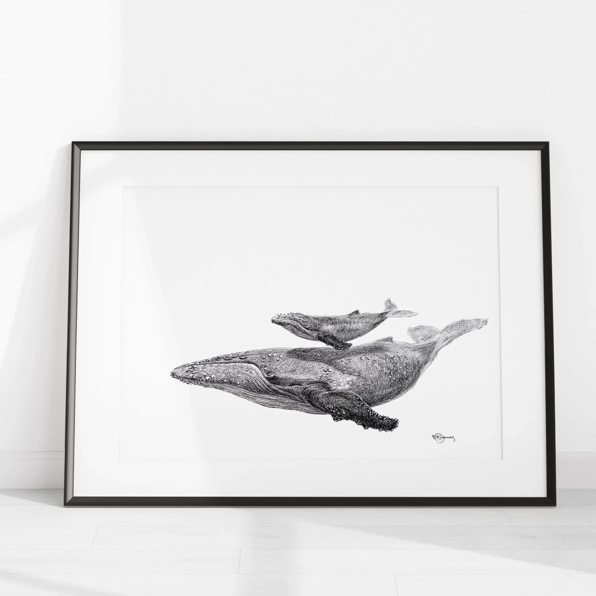 Black and white whale with calf illustration in a frame on a white floor