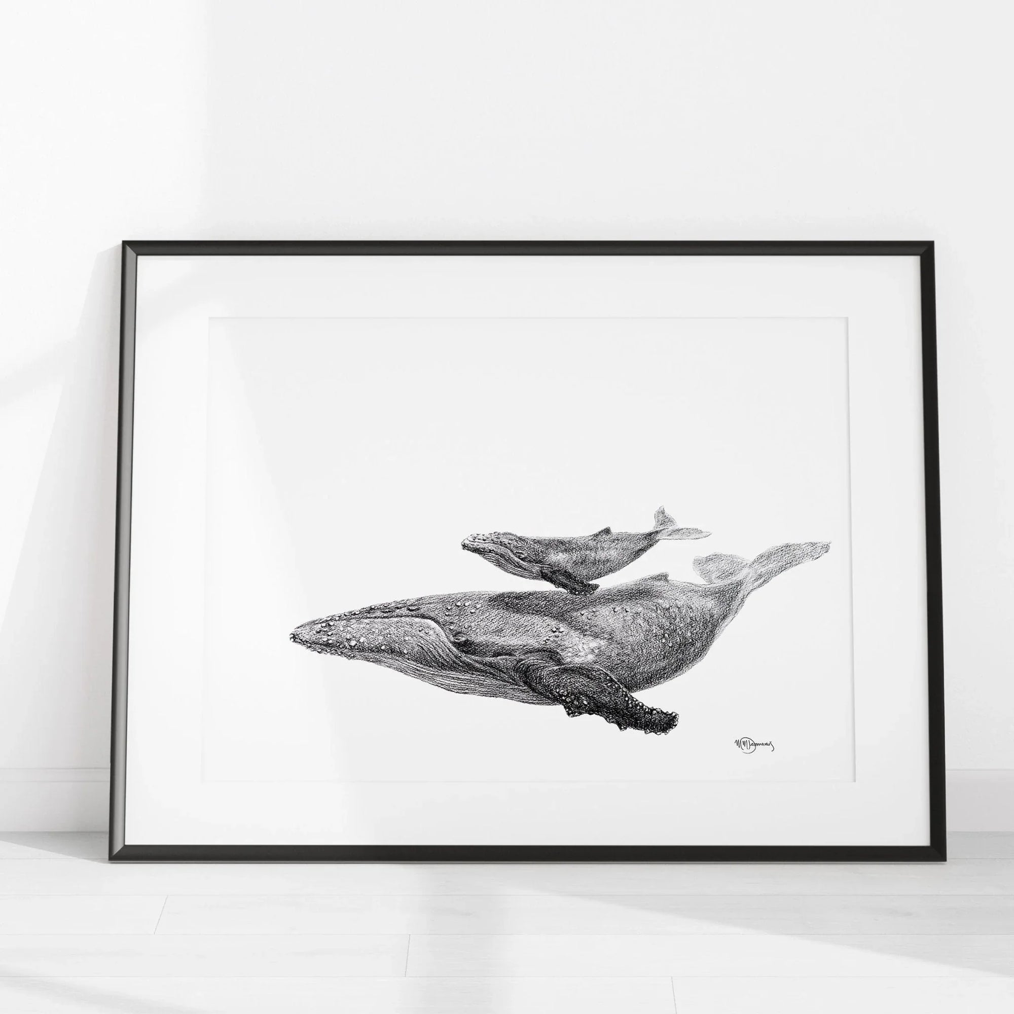 Black and white whale with calf illustration in a frame on a white floor