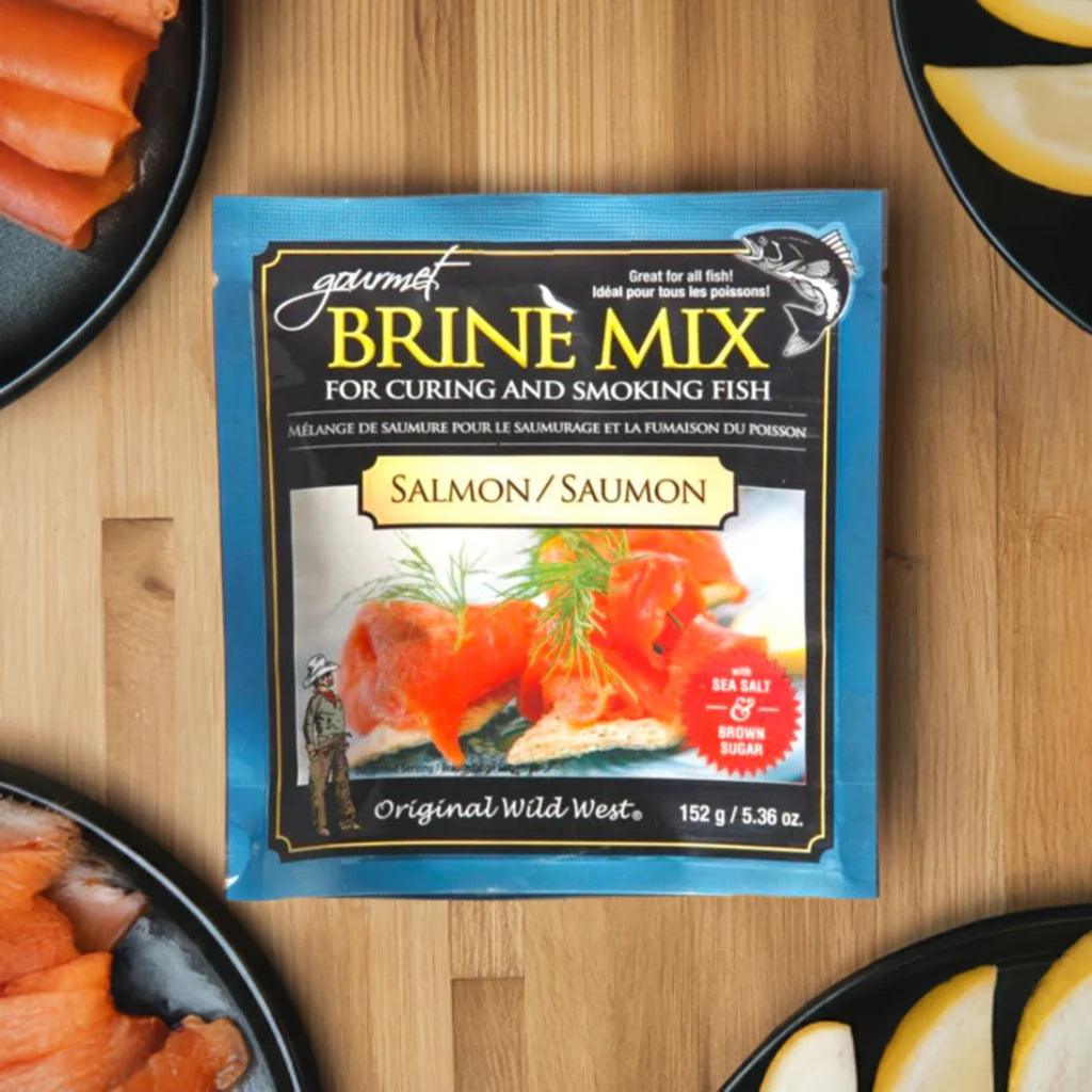 Salmon brine mix packet for curing and smoking fish on wood table, with sliced salmon and lemon on plates
