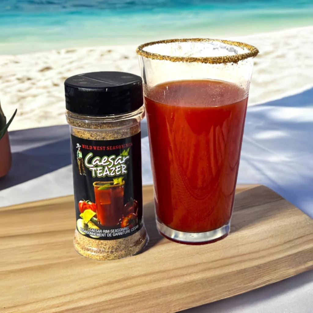 Caesar Teazer seasoning and Caesar cocktail on wood board by ocean beach