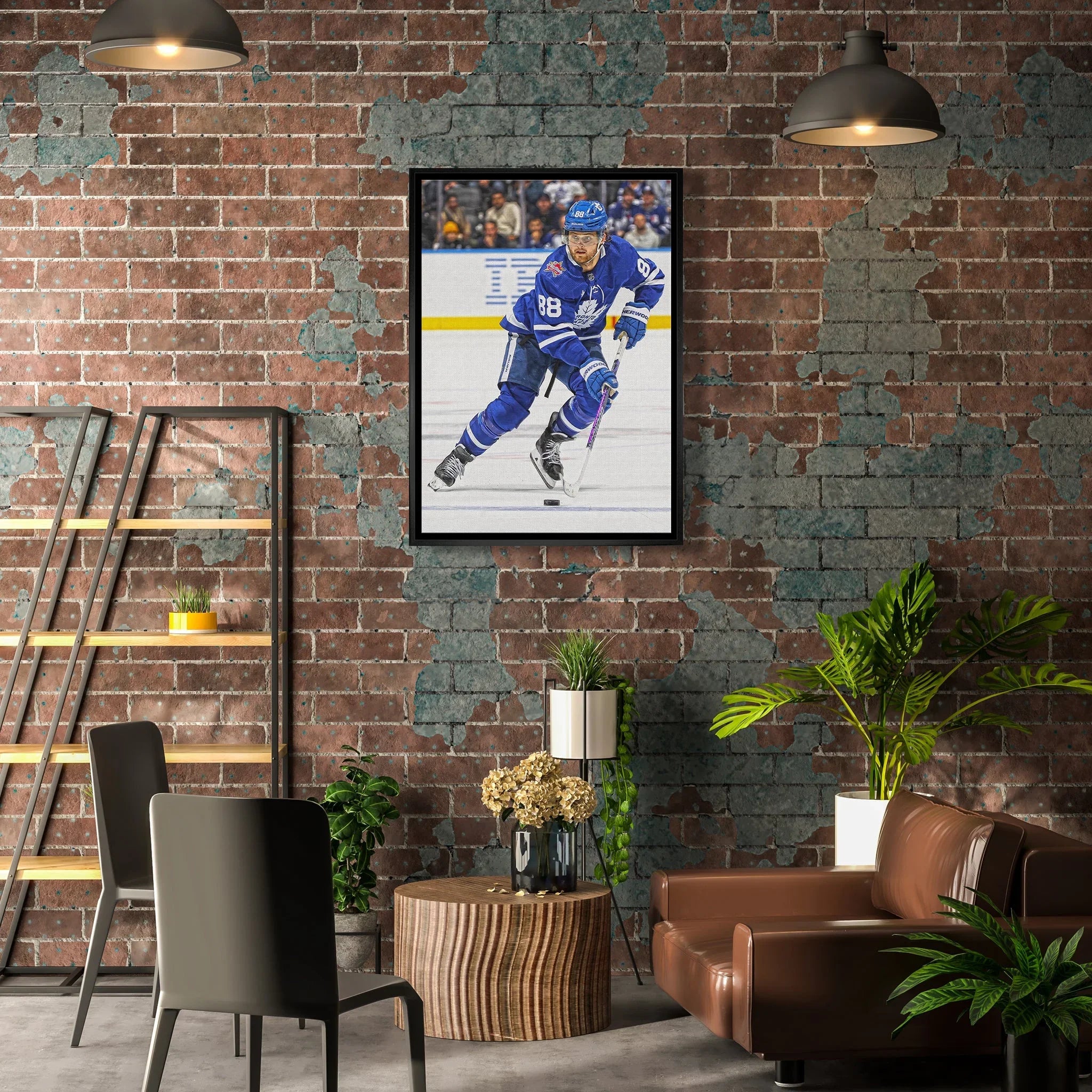 Modern loft living room with exposed brick wall, hockey player artwork, plants, and leather couch