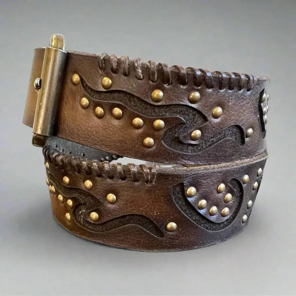 Women's full grain leather belt with geometric embossing and brass studs on gray background