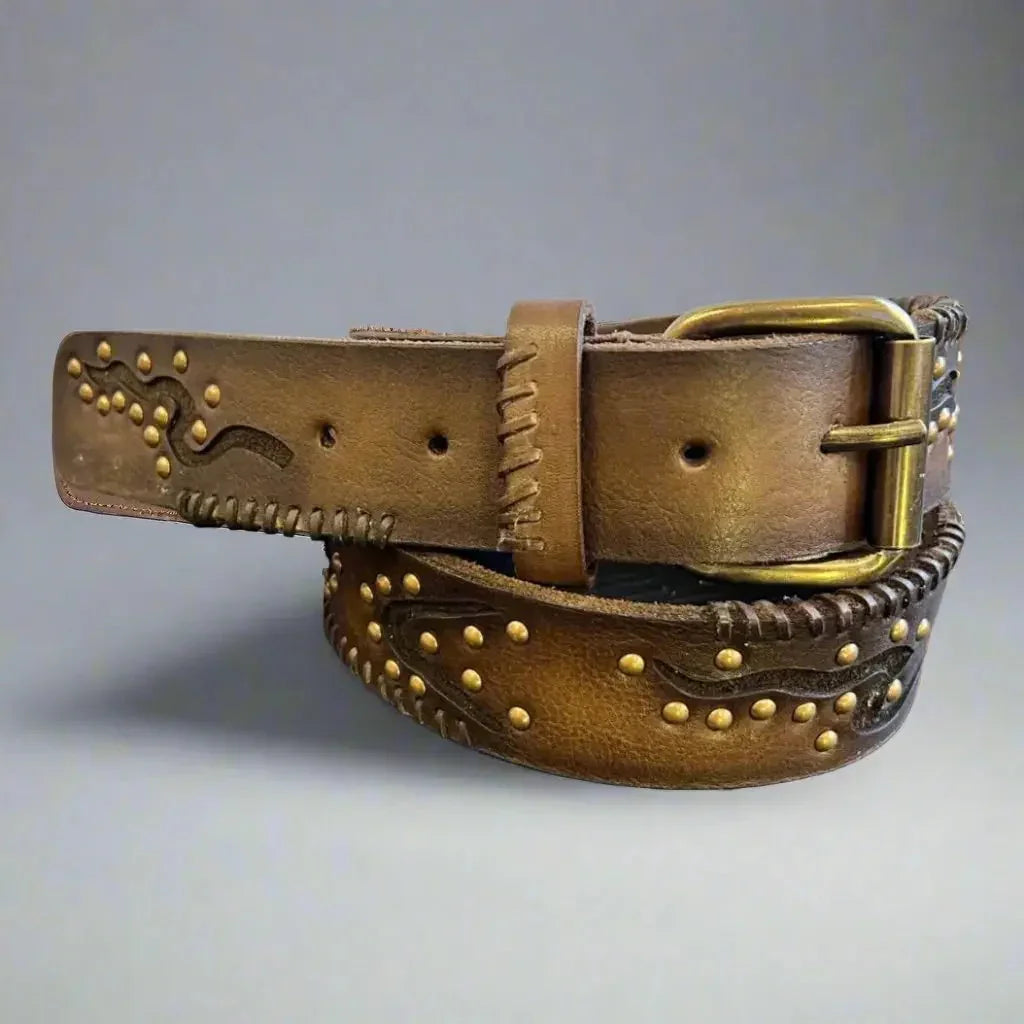 Women's full-grain leather belt with geometric embossing and metal studs on gray background
