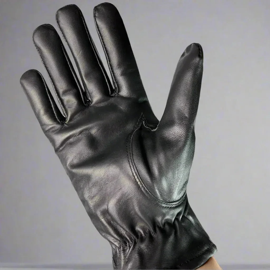Women's genuine black leather glove on hand against plain background