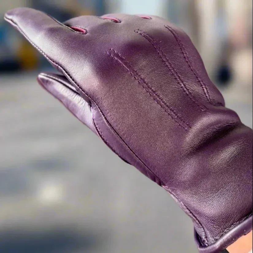 Women's purple leather glove with stitched detail in outdoor setting