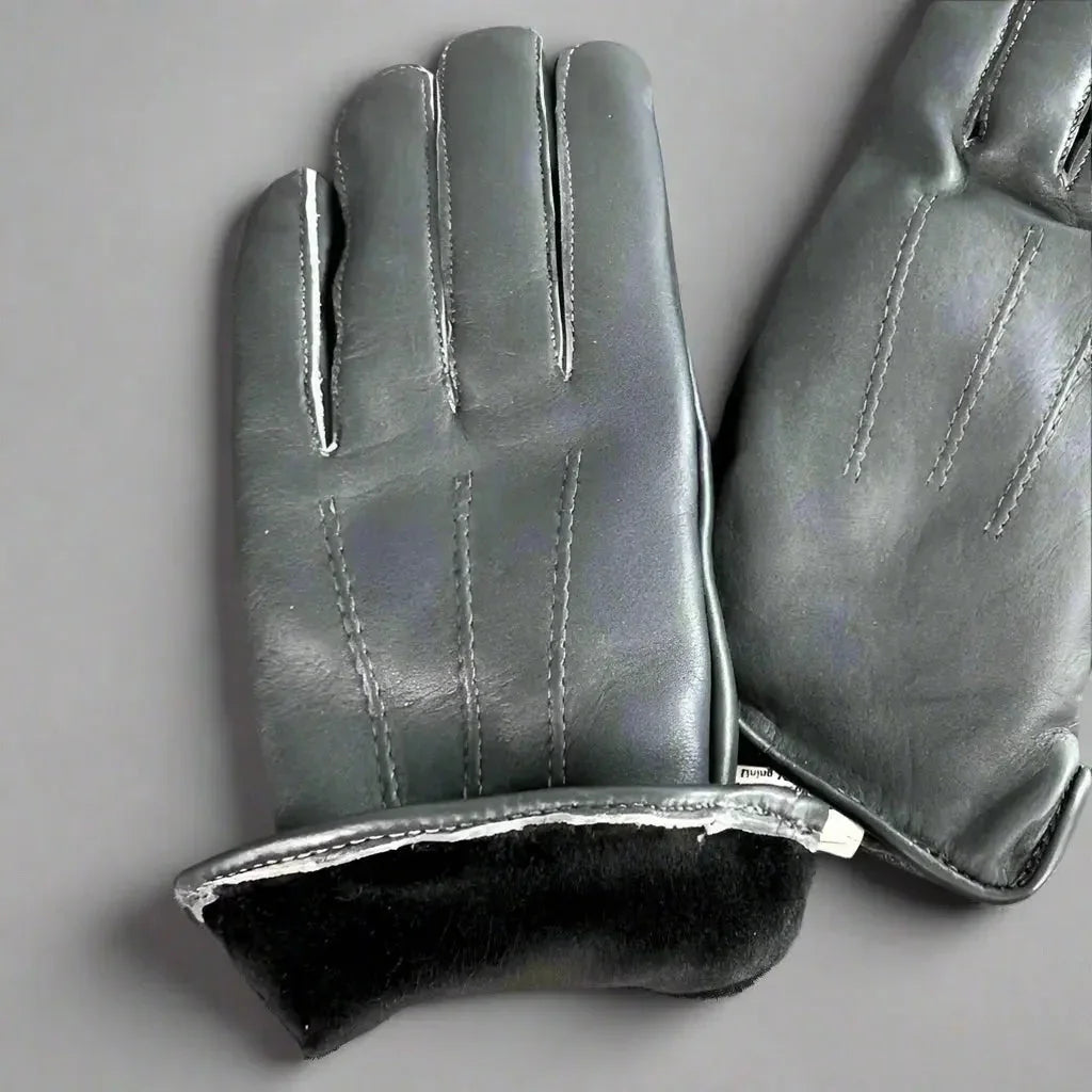 Women's black leather gloves with black fur lining on a gray background