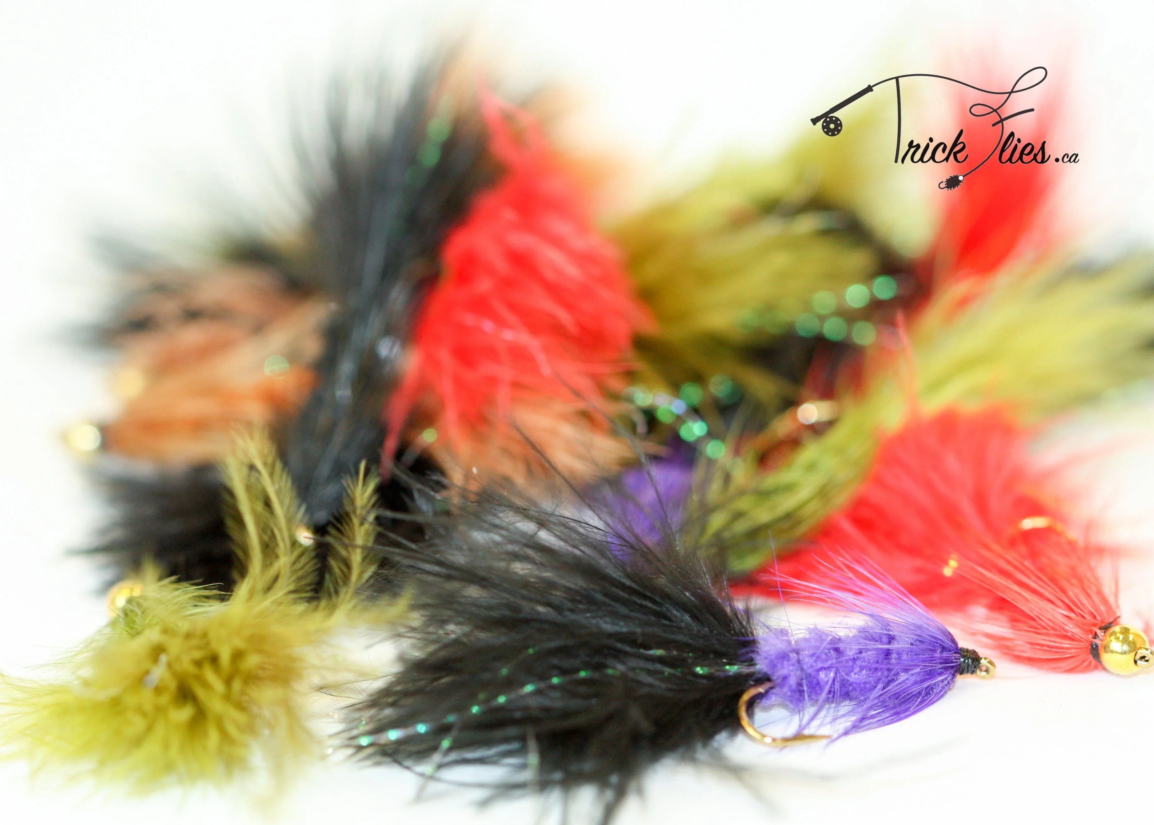 Colorful marabou streamer fishing flies on white background, Trick Flies logo visible