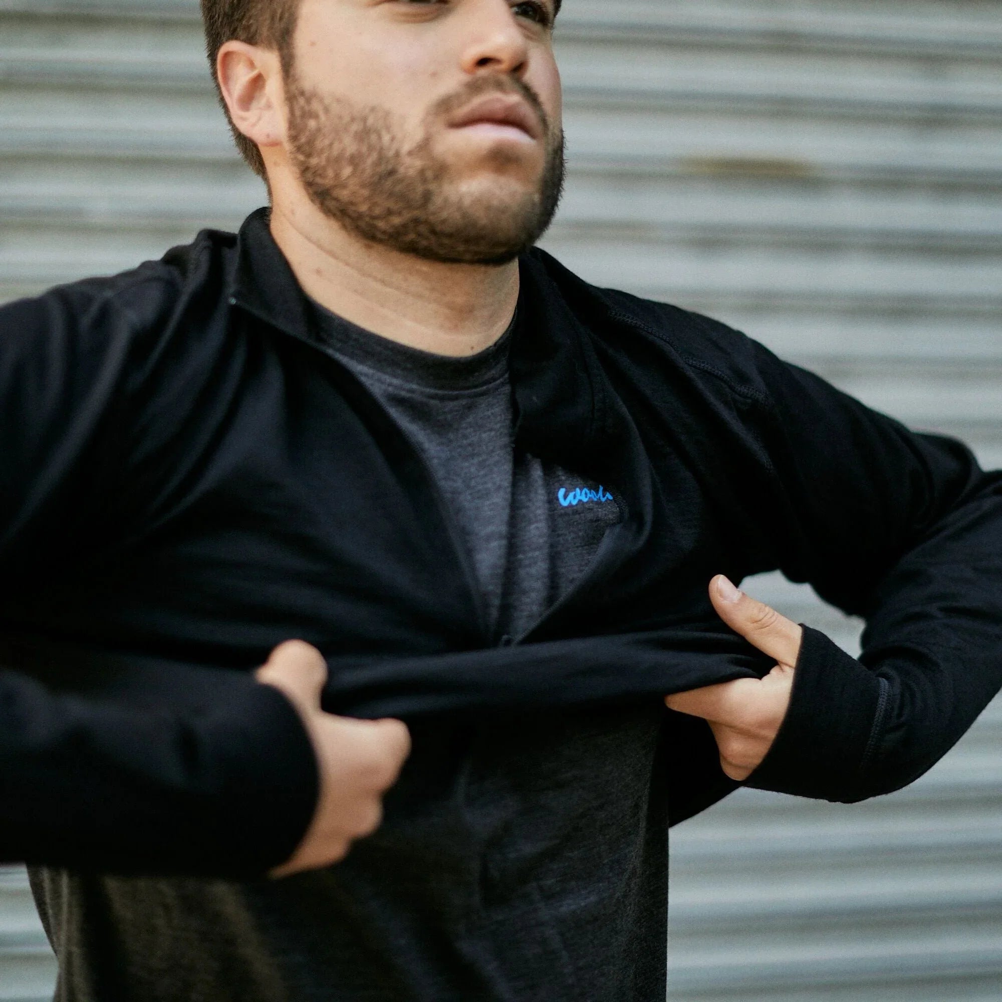 Man wearing men's black 100% merino wool quarter zip baselayer pullover outdoors