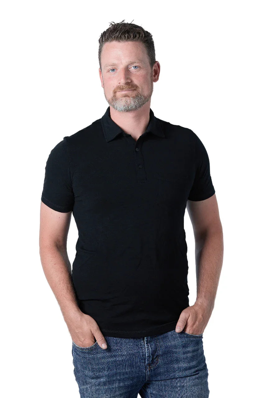 Man wearing black Woolove men's golf polo shirt and blue jeans on white background