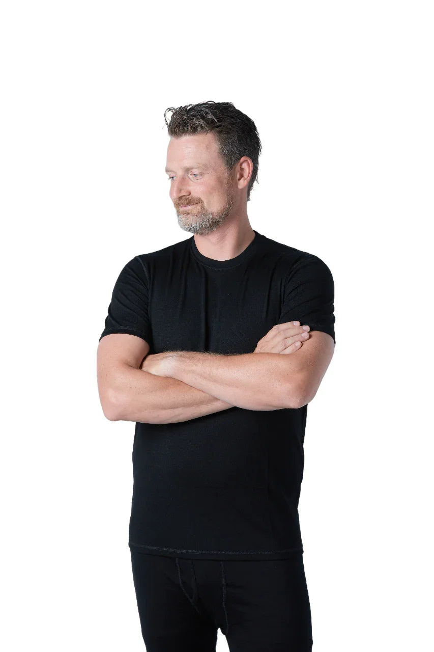 Man wearing black merino wool t-shirt, arms crossed, white background