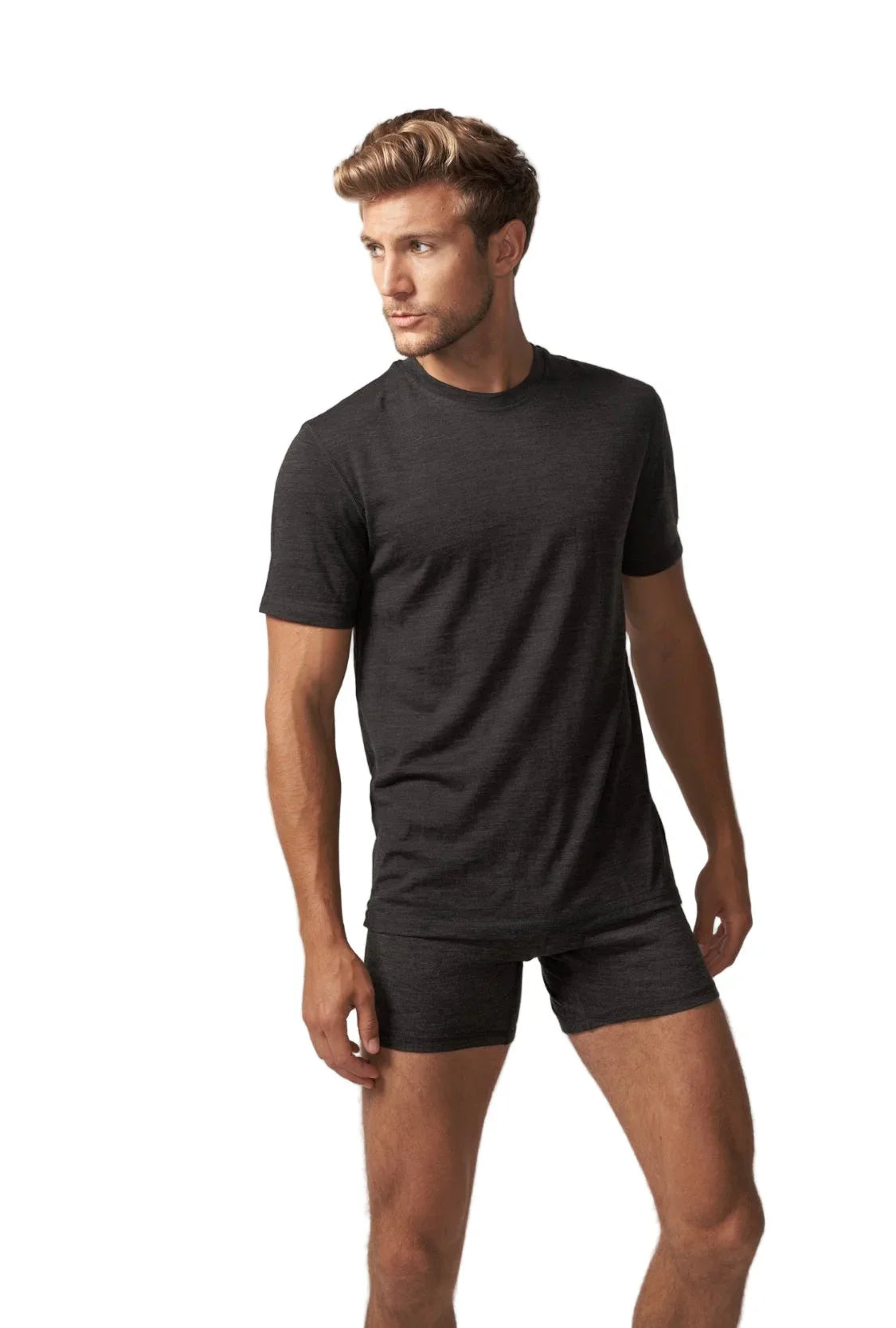 Man wearing black 100% merino wool short sleeve T-shirt and boxer briefs on white background