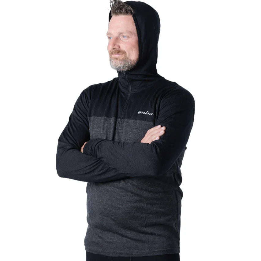 Man wearing black Woolove men's quarter zip Merino wool hoodie, arms crossed