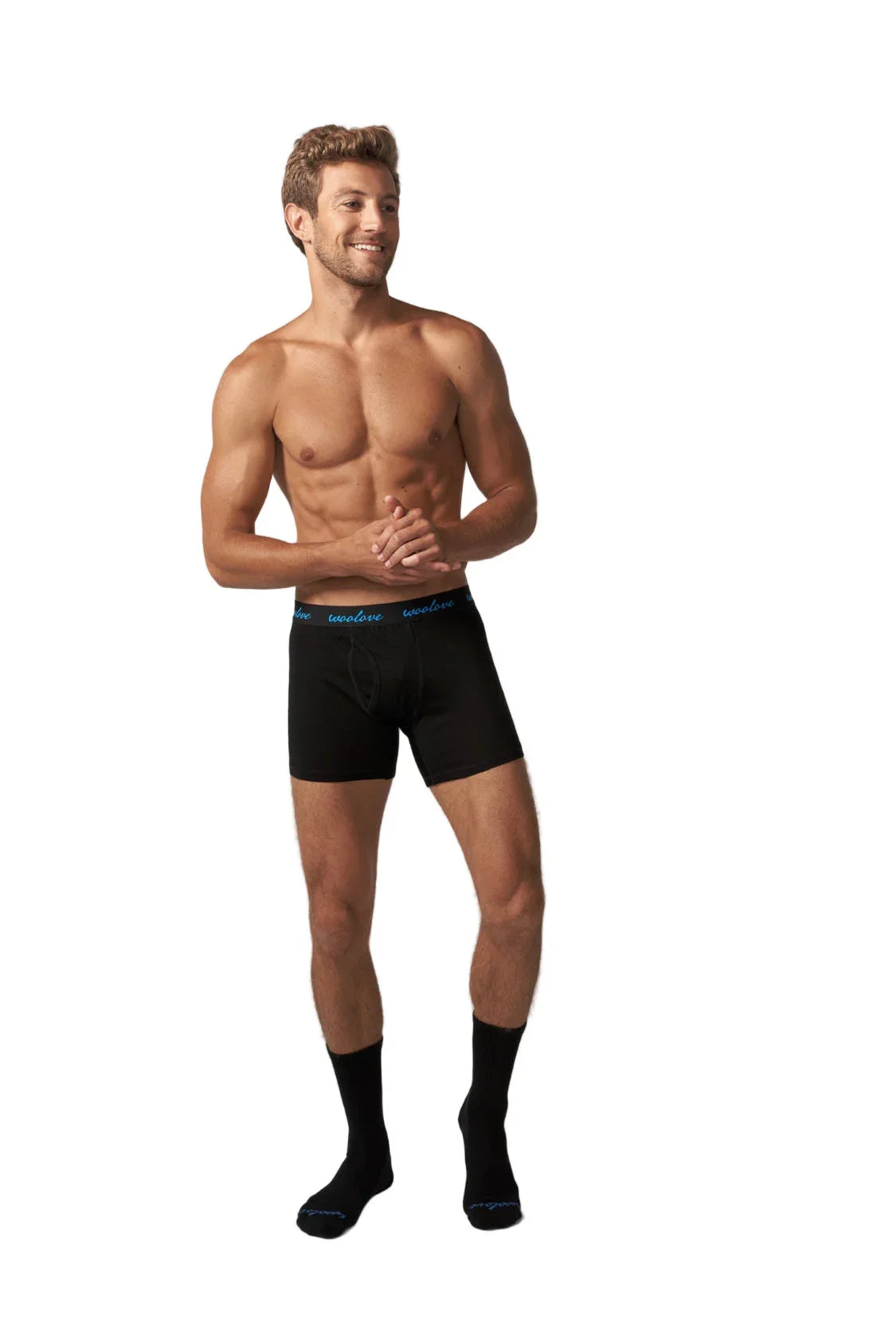 Man modeling black Woolove merino boxers and merino socks on white background