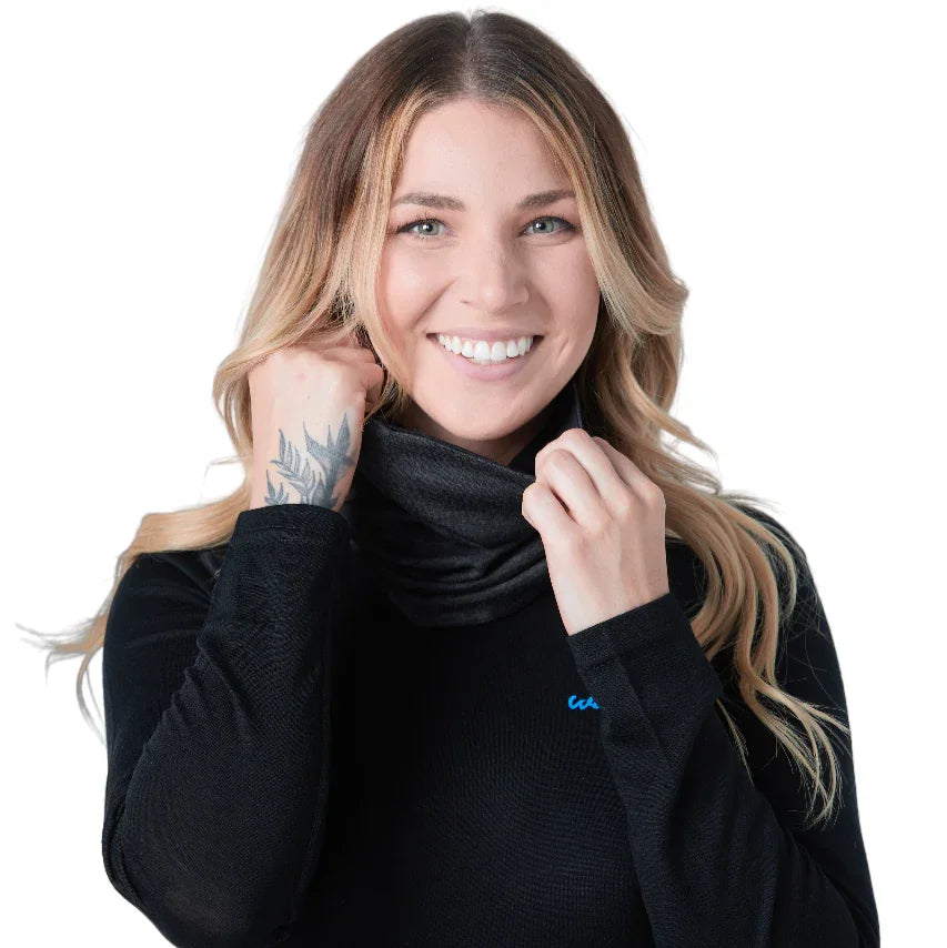 Smiling woman in a black long sleeve shirt wearing a black neck gaiter on white background