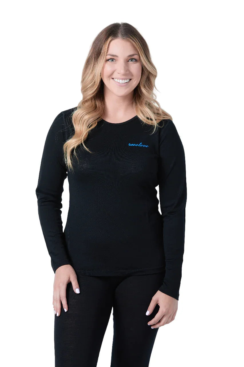 Woman wearing black Woolove women's long sleeve merino wool shirt, white background