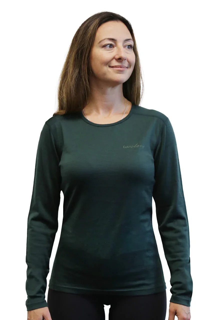 Woman wearing a dark green women's long sleeve shirt on a white background