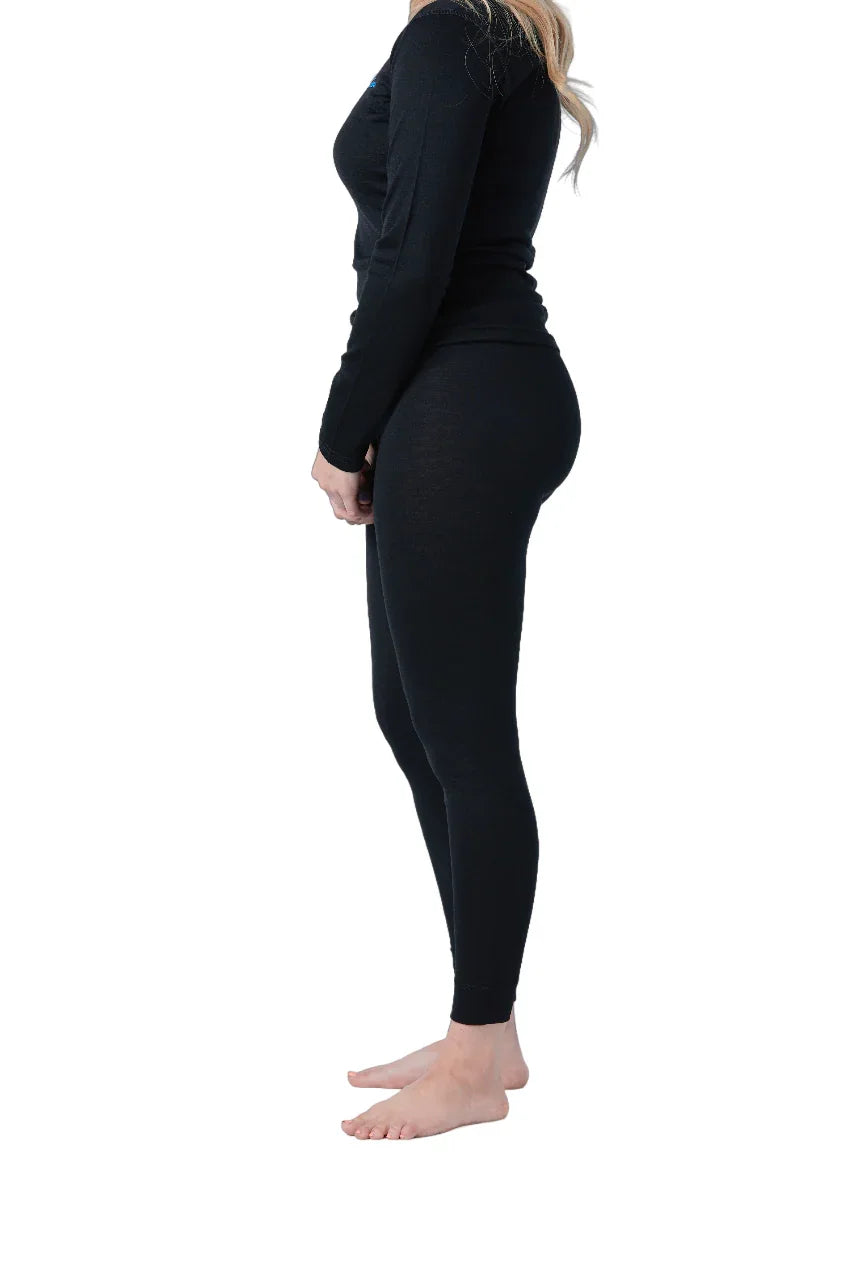 Woman wearing black merino wool leggings and long sleeve top, side view on white background