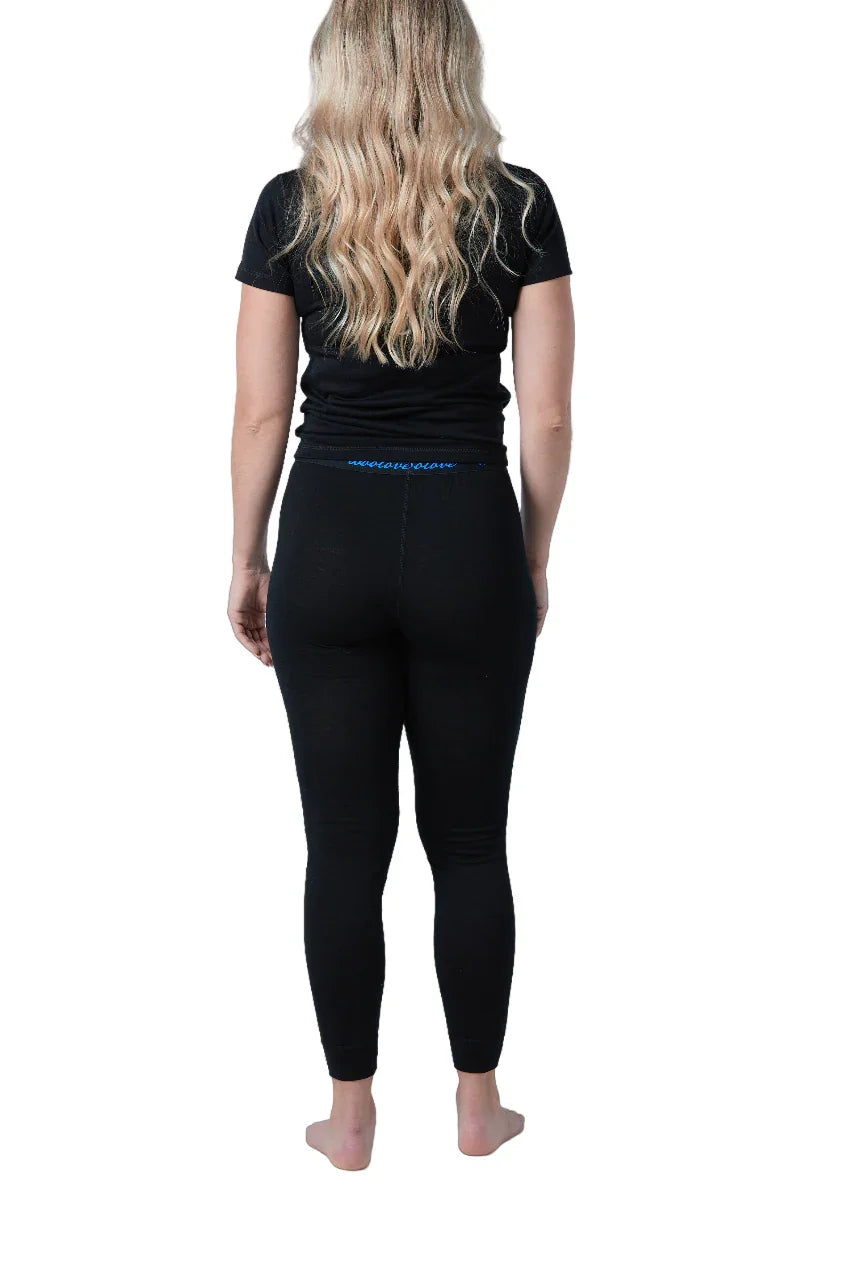 Back view of woman wearing black merino wool leggings and t-shirt on white background