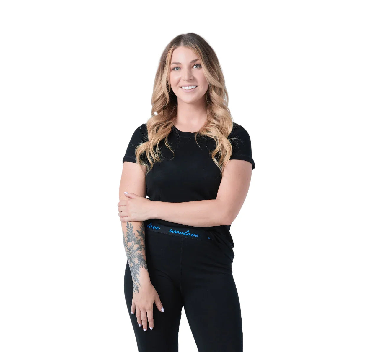 Woman wearing black Woolove women's merino wool t-shirt and leggings, white background