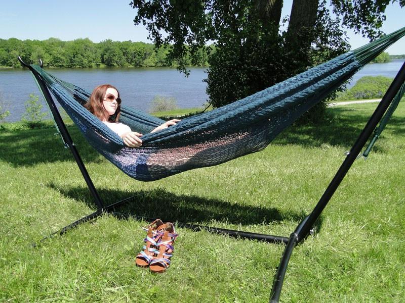 Woman relaxing in Mayan hammock on XL universal hammock stand by lakeside in park