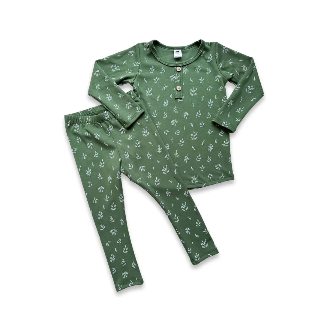 Green kids pajama set with long sleeves and white leaf print on white background