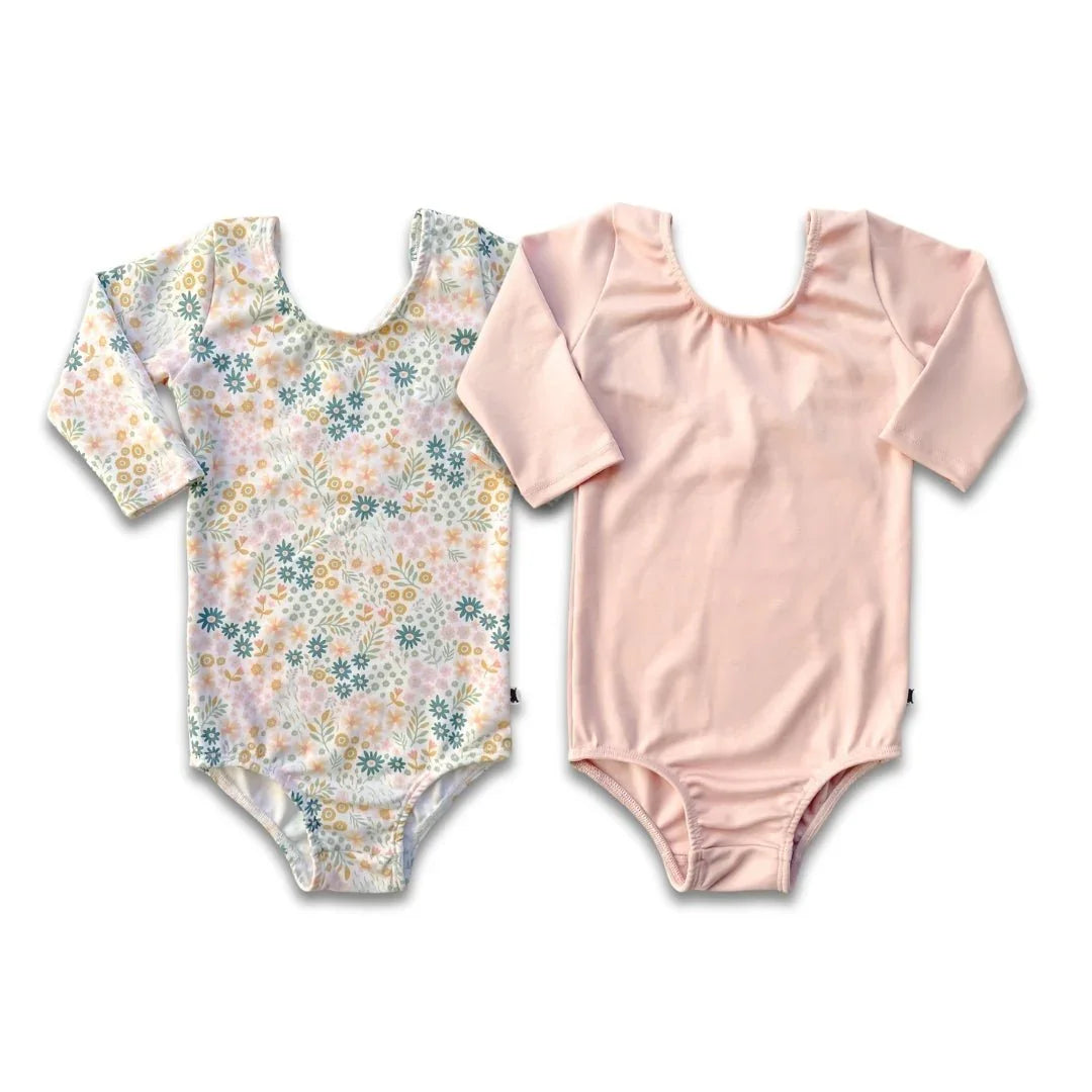 Two youth bamboo Audrey bodysuits, one pink and one with a pastel floral print, side by side.