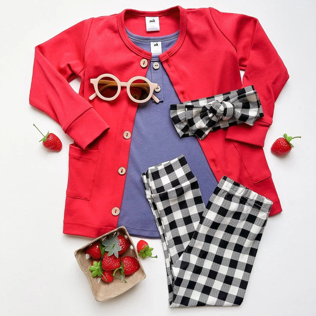 Kids' outfit with red cardigan, plaid headband and pants, purple shirt, sunglasses, strawberries