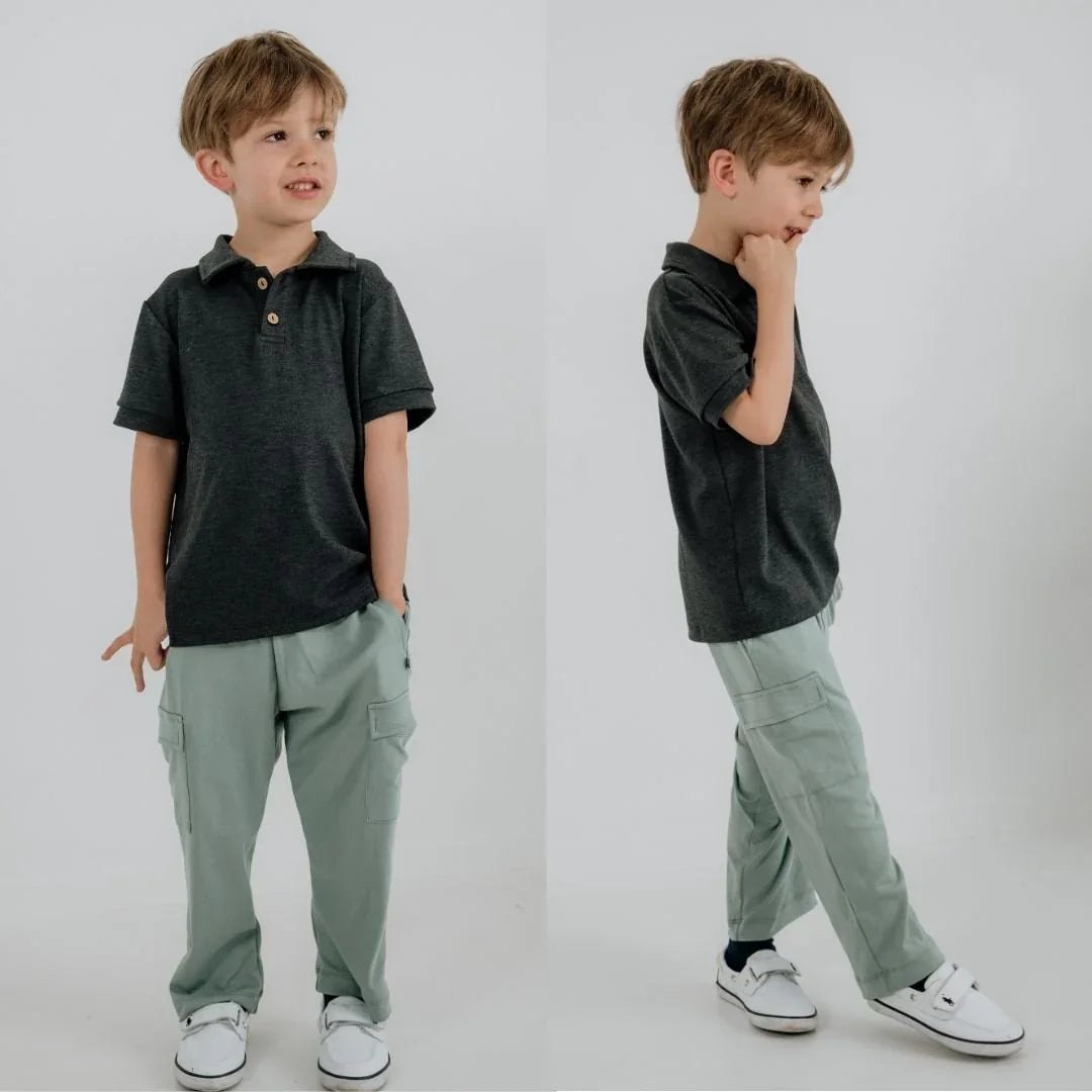Boy wearing bamboo cargo pants and dark polo shirt on white background