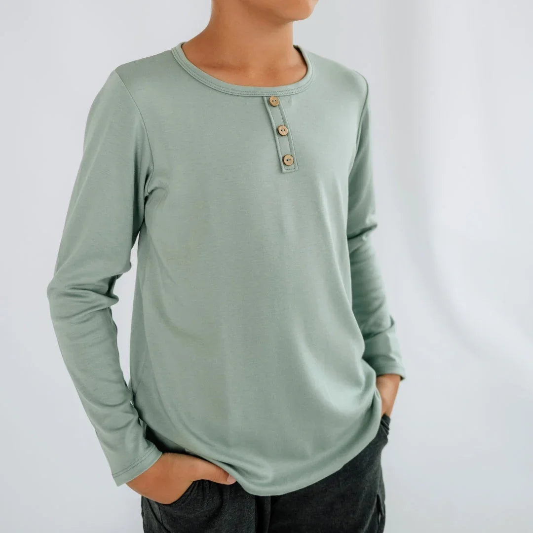 Youth wearing sage green long sleeve Henley shirt with wooden buttons