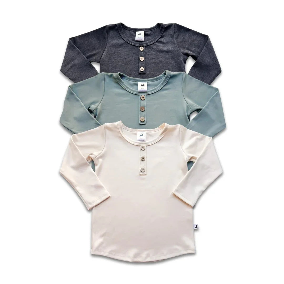 Three youth bamboo Henley long sleeve shirts in cream, sage, and charcoal colors, flat lay