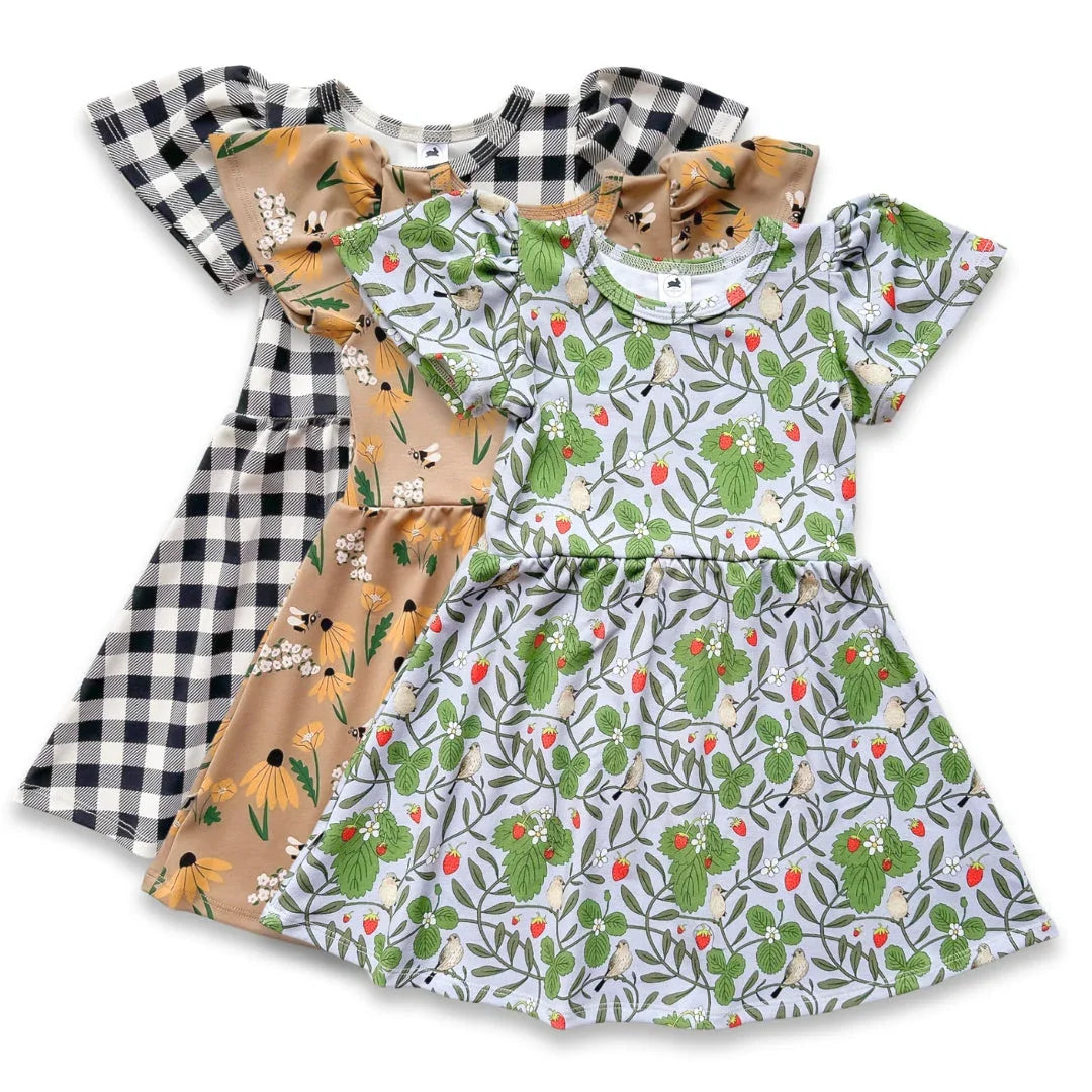 Three short-sleeve girls dresses, floral, checkered, and botanical hedgehog patterns