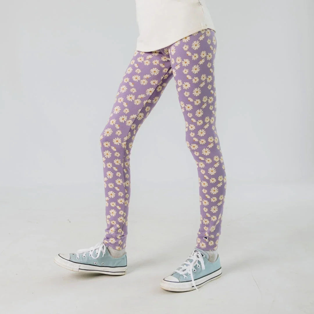 Youth bamboo leggings with daisy print in lavender, casual sneakers, neutral background