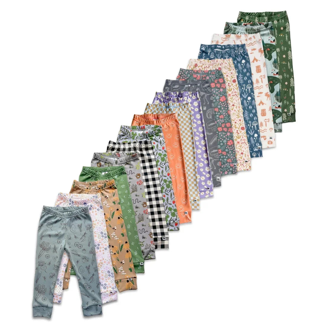 Assorted youth leggings with colorful, floral, animal, and geometric prints on white background