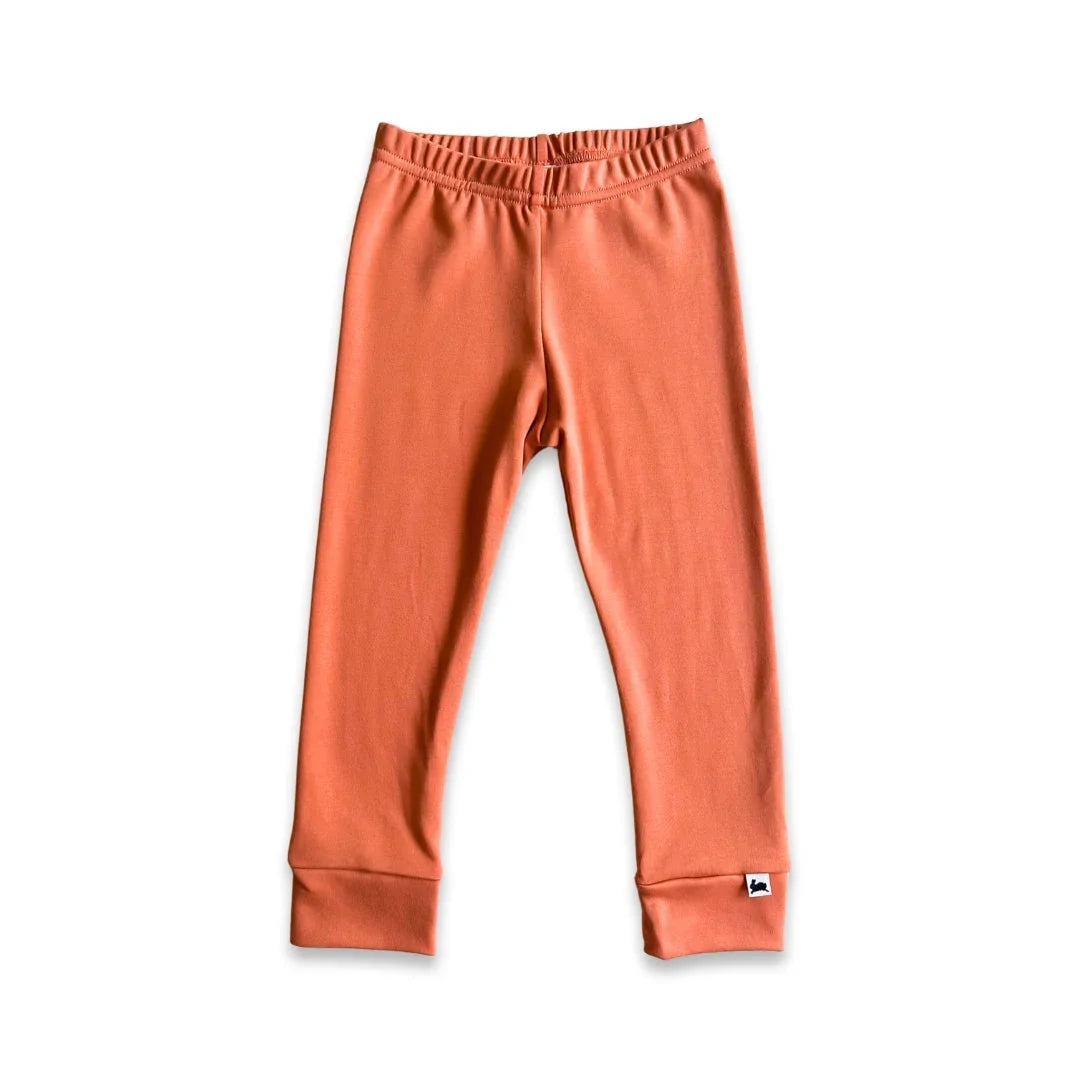 Rust orange kids leggings with elastic waist and cuffed ankles on white background