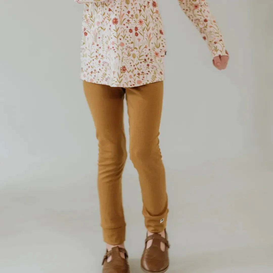 Youth bamboo leggings in solid tan color, worn with floral top and brown shoes