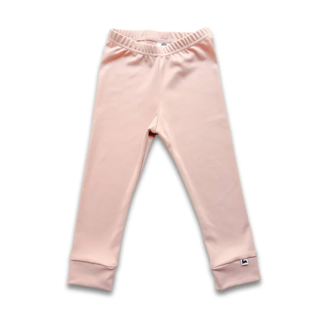 Youth bamboo leggings in solid pale pink, elastic waistband, folded cuffs, on white background.